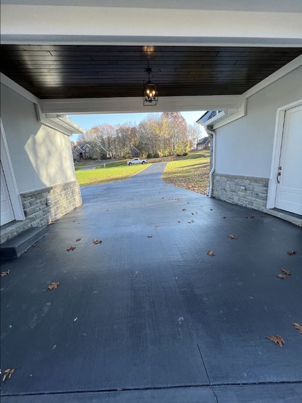 Finished concrete driveway under a covered residential entry